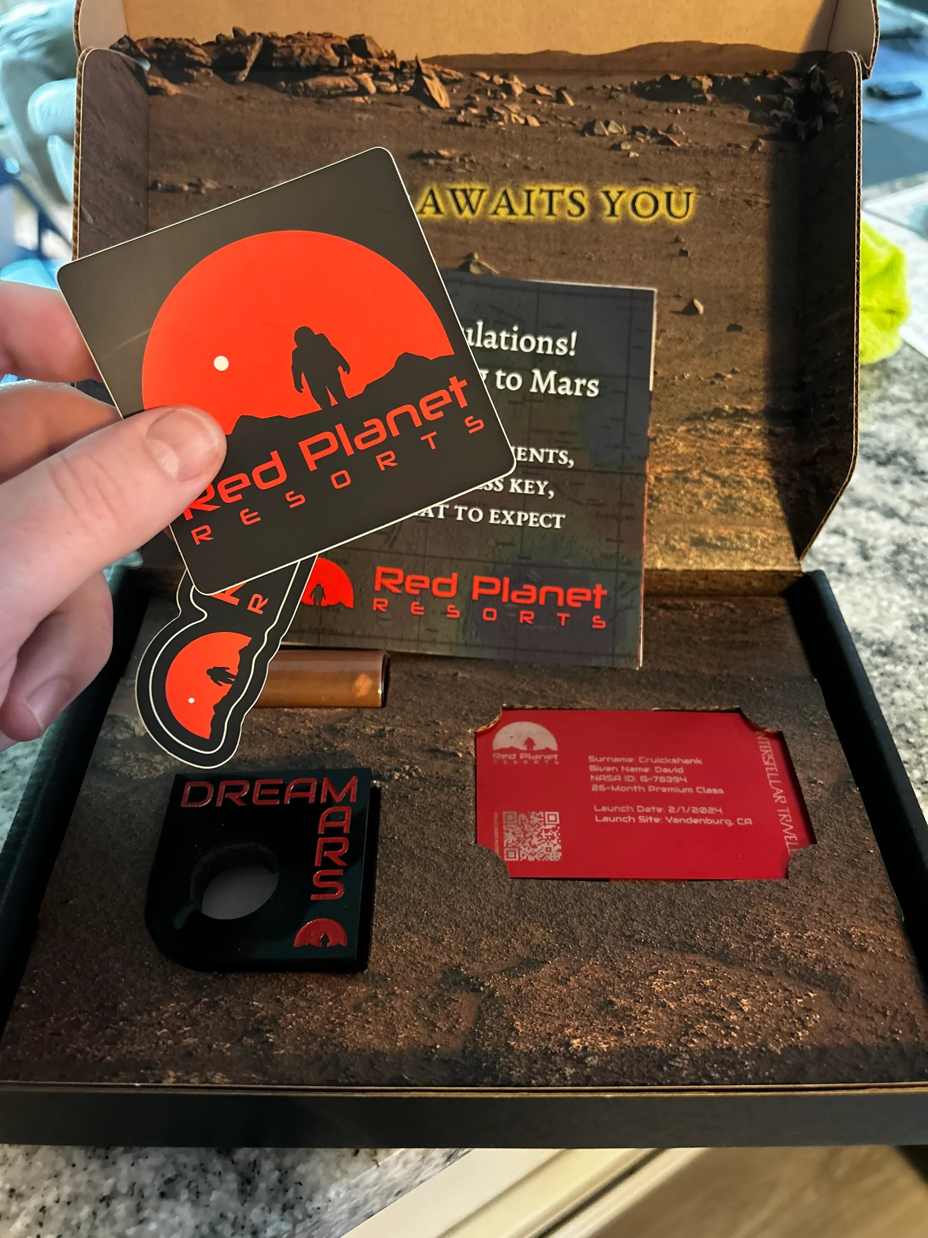 Red Planet Resorts Mars travel kit with stickers, keychain, and Mars mission welcome card in box