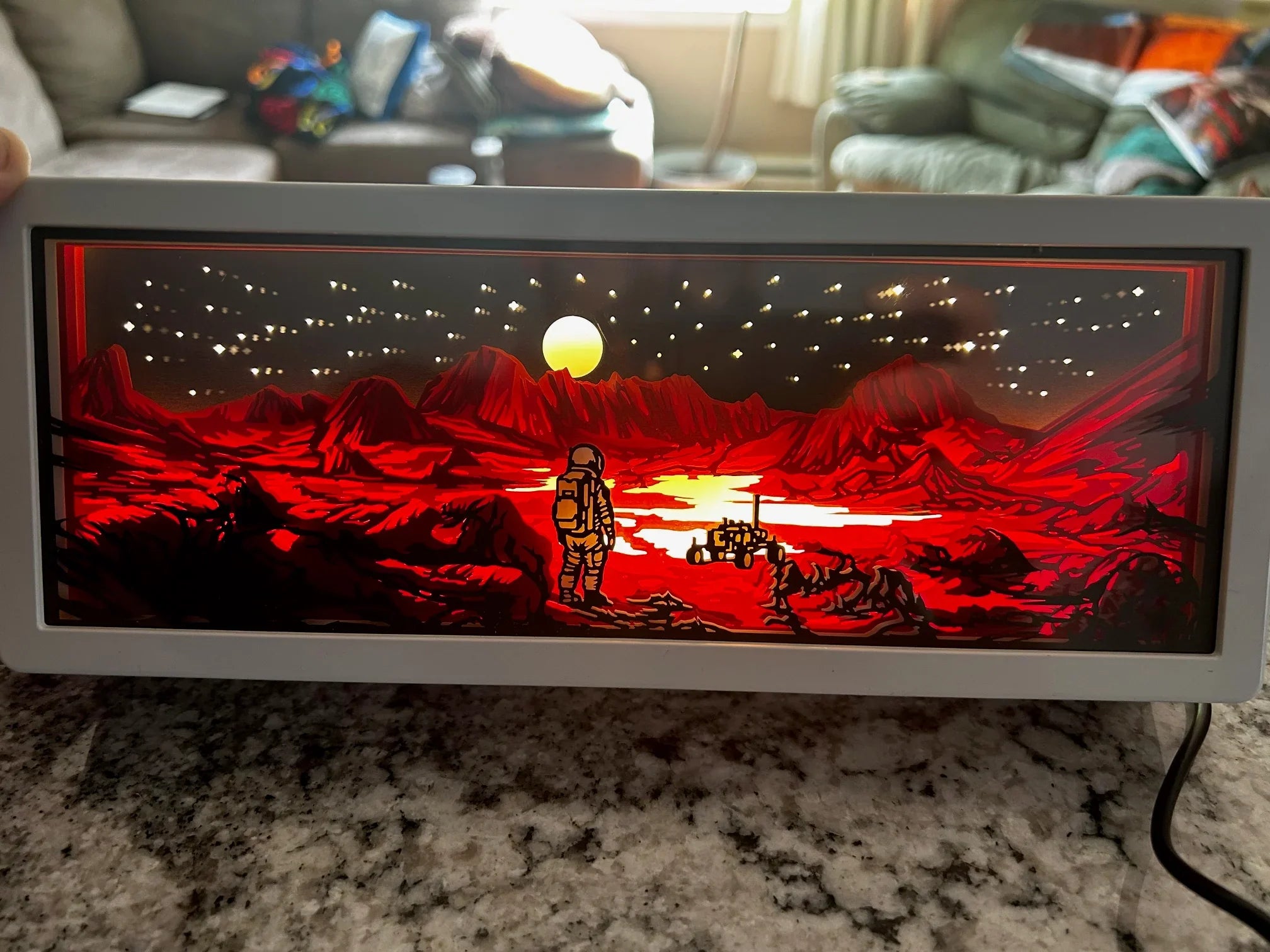 Illuminated LED lightbox showing astronaut and rover on red rocky alien landscape under starry sky