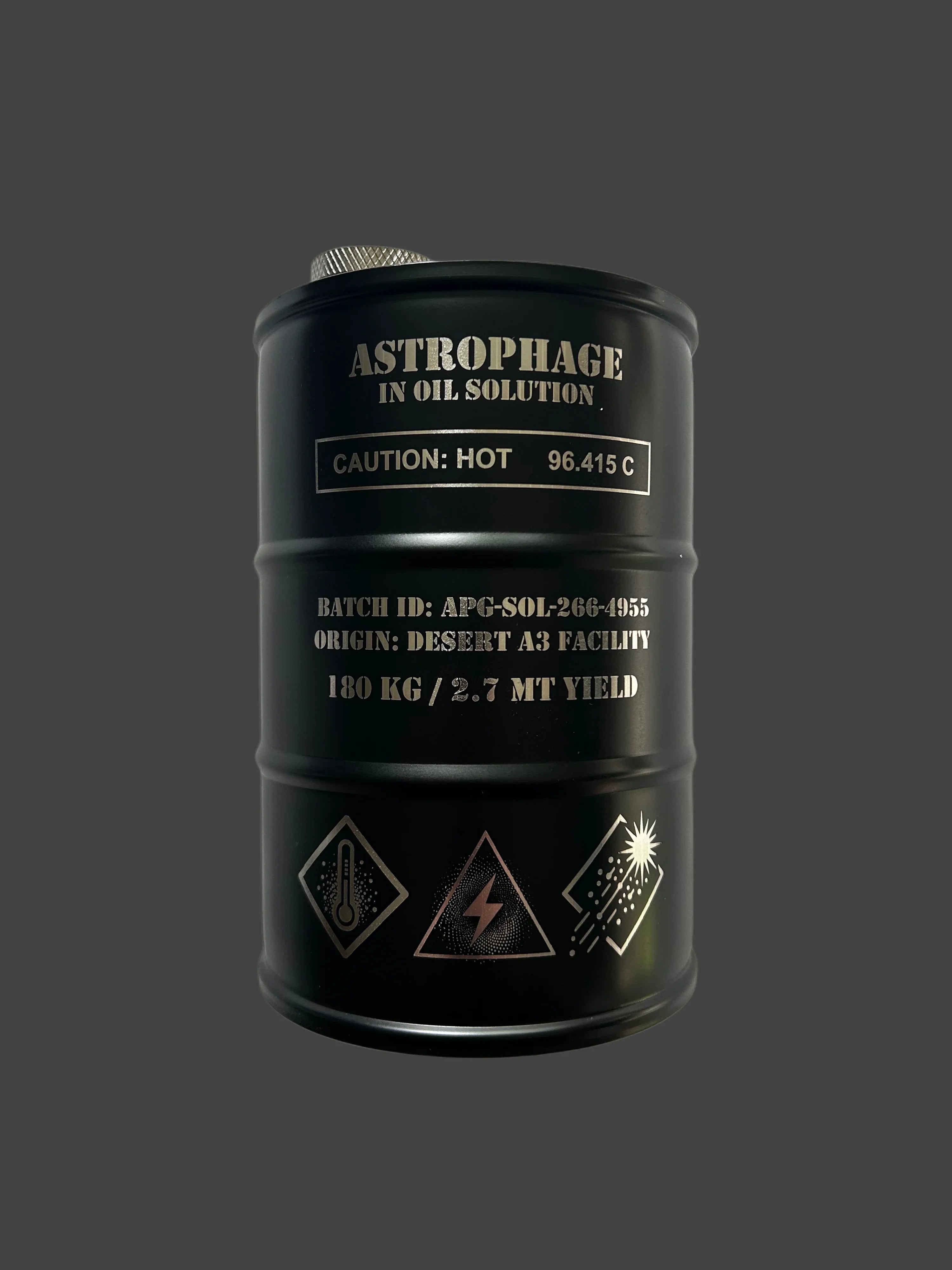 Black barrel labeled Astrophage in oil solution with caution hot 96.415°C, batch ID and hazard symbols