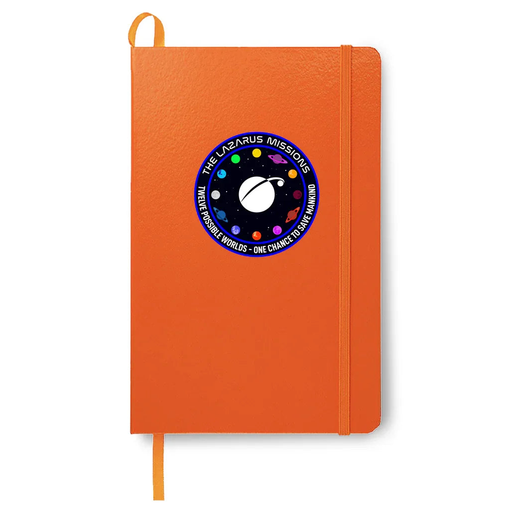 Orange notebook with elastic band and space mission patch labeled The Lazarus Missions and twelve planets