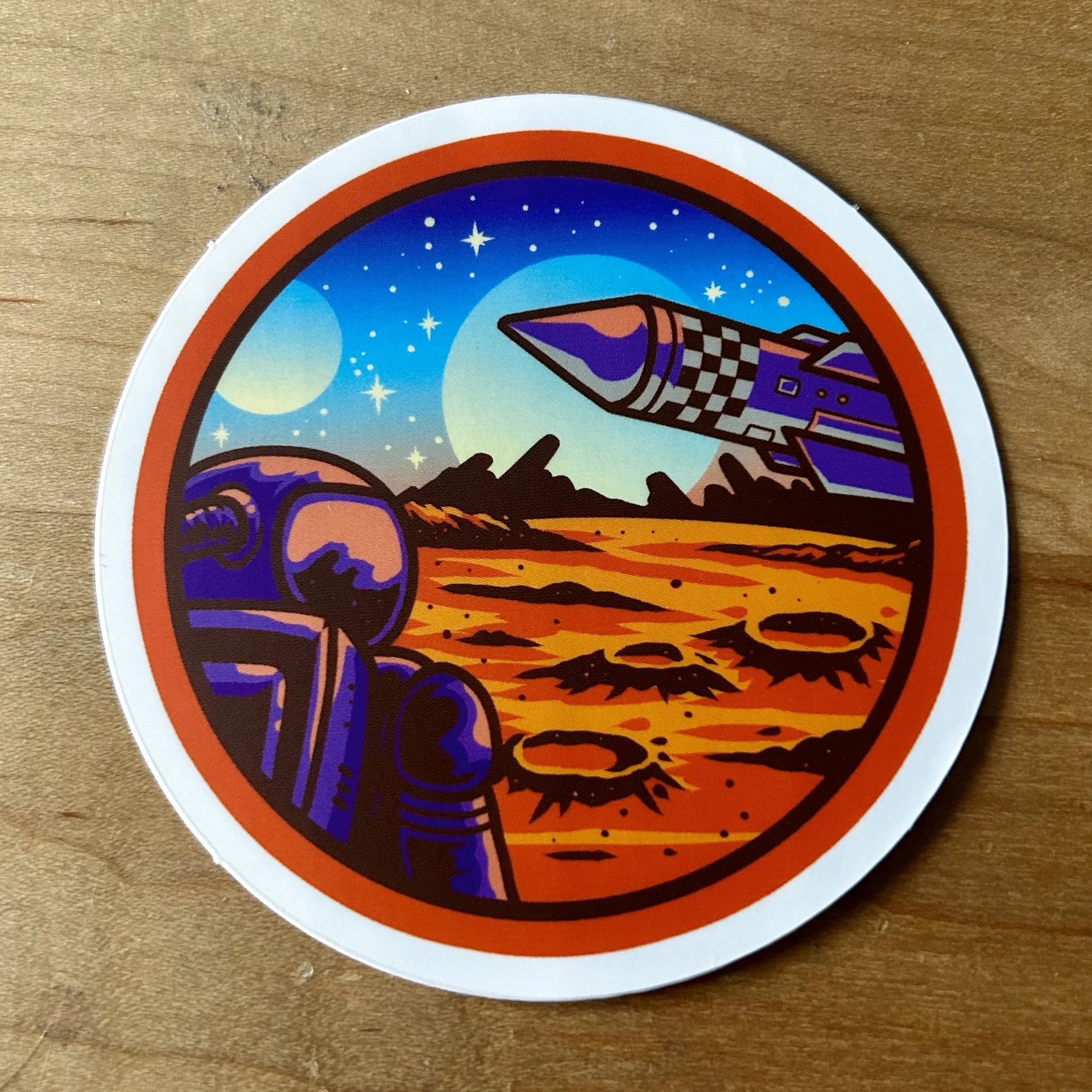 Round sticker of astronaut on red rocky planet surface with craters and a rocket launching into starry sky