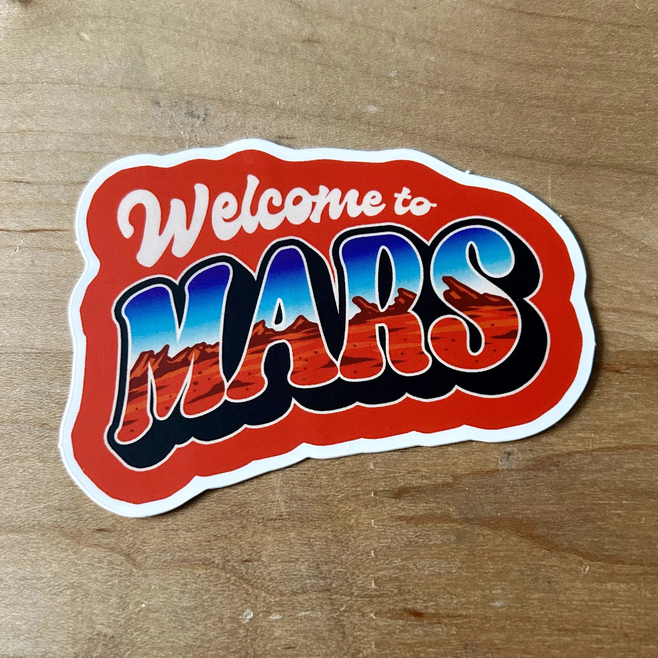 Retro red sticker on wood saying 'Welcome to Mars' with Mars landscape illustration