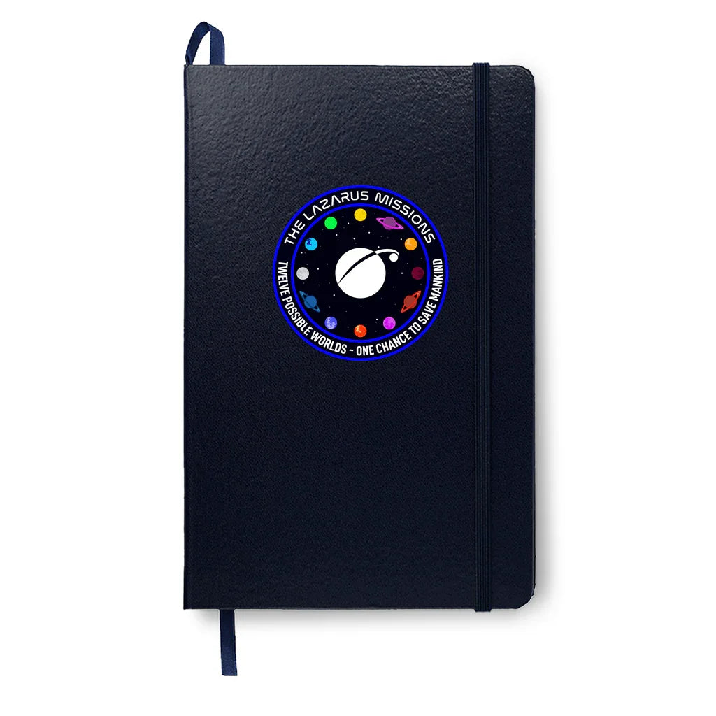 Black textured notebook with elastic band and space mission patch reading The Lazarus Missions, colorful planets around logo